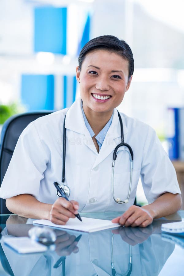 Download Écriture Heureuse De Docteur Sur Un Carnet Et Sourire à L'appareil-photo Image stock - Image du verticale, bureau: 56482123
