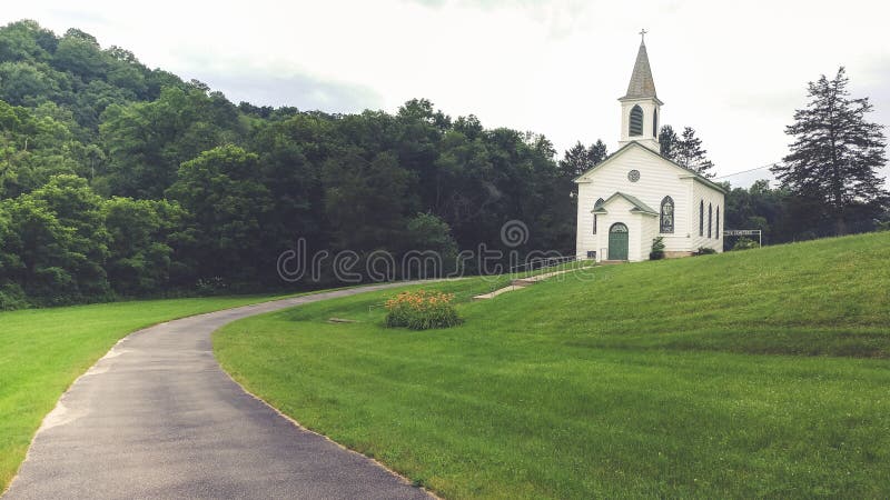 Église blanche de pays sur Hillside herbeux