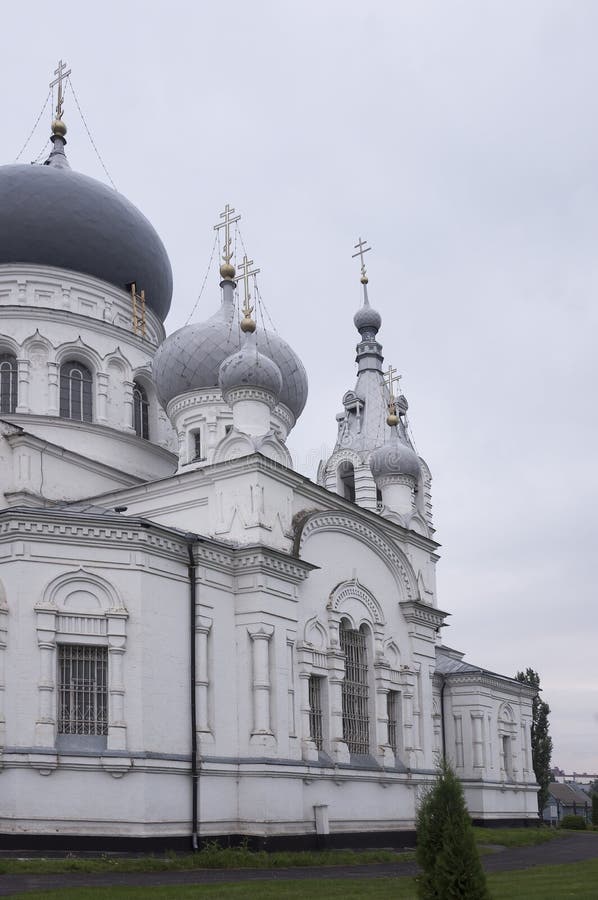 Église blanche orthodoxe chrétienne avec les dômes argentés et gris avec des croix d'or Ciel gris calme ci-dessus image stock Église blanche orthodoxe chrétienne avec les dômes argentés et gris avec des croix d'or Ciel gris calme ci-dessus image stock