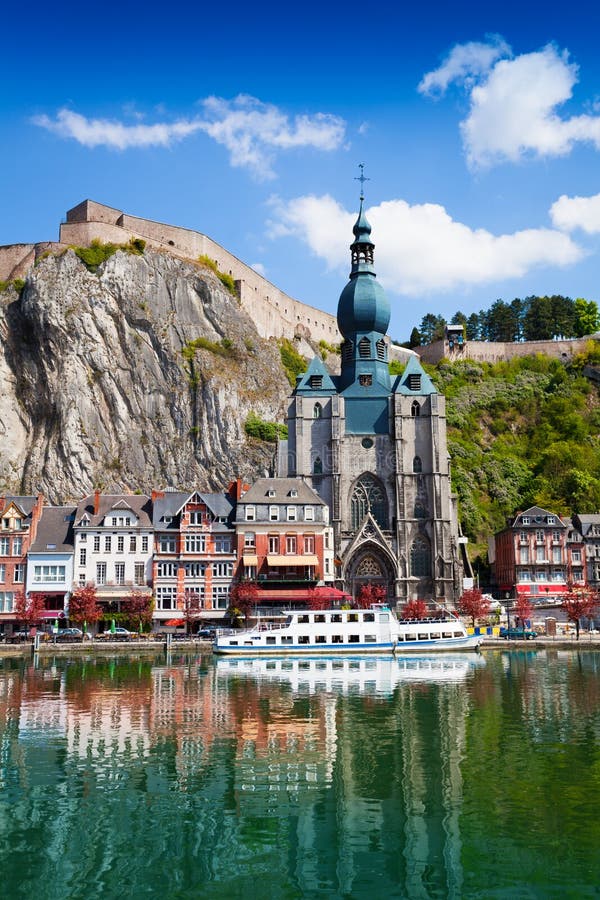 Dinant Collegiate Church of Our Lady near Meuse river with white ship in Belgium. Dinant Collegiate Church of Our Lady near Meuse river with white ship in Belgium.