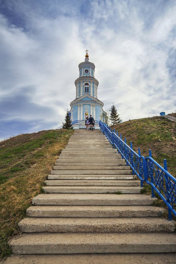 Thelma village, Irkutsk region, Russia - MAY - 09 2016: Two students walking down the stairs near the Church of the Kazan Icon of the Mother of God. Thelma village, Irkutsk region, Russia - MAY - 09 2016: Two students walking down the stairs near the Church of the Kazan Icon of the Mother of God.