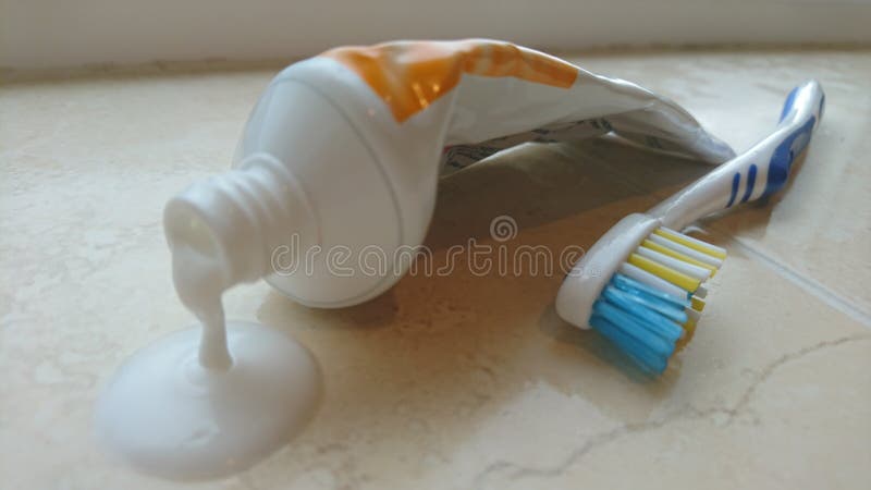 Égoutture de pâte dentifrice hors du tube avec la brosse à dents