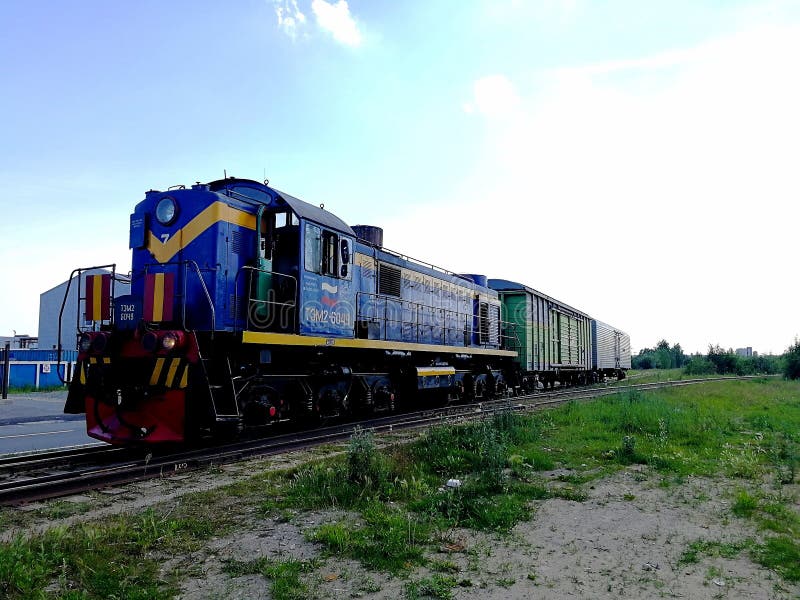 Él locomotora es azul con dos carros cubiertos en el ferrocarril Visi?n correcta fotografía de archivo Él locomotora es azul con dos carros cubiertos en el ferrocarril Visi?n correcta fotografía de archivo