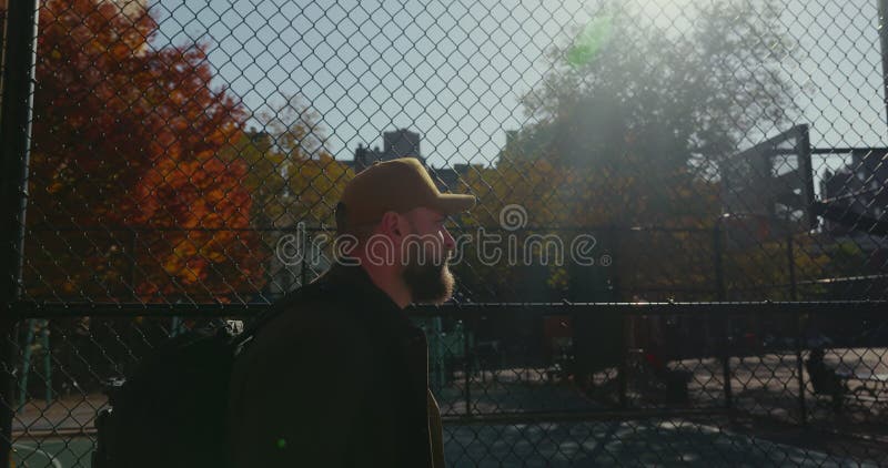 élégant beau mâle barbu avec une casquette explorant la banlieue ensoleillée de new york. banque de vidéos