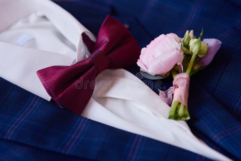 Elegant blue male suit with white shirt and red bowtie background, copy space. Modern men accessories. Wedding details. Top view, flat lay. Elegant blue male suit with white shirt and red bowtie background, copy space. Modern men accessories. Wedding details. Top view, flat lay