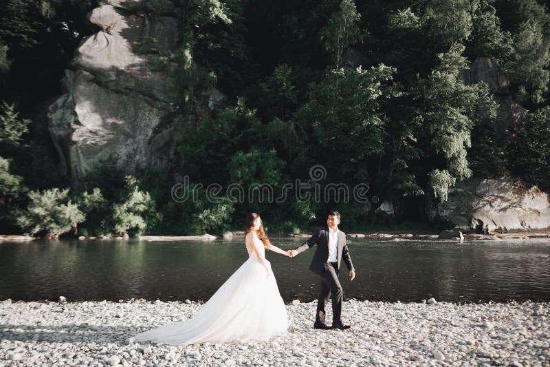 élégant joli marié blonde et beau marié sur le fond d'une belle rivière dans les montagnes image stock