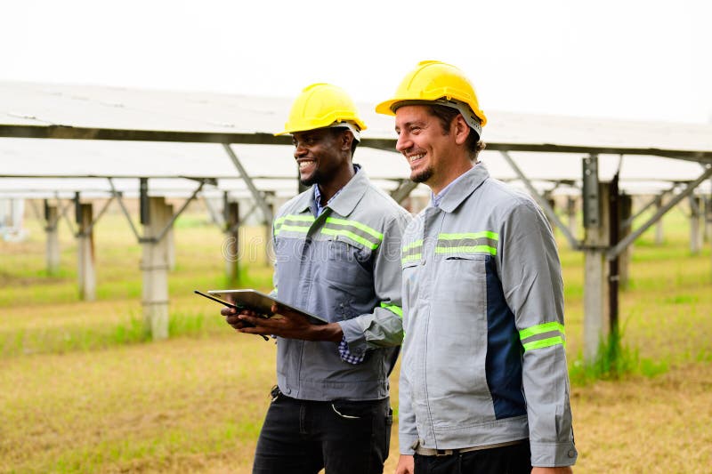 équipe d'ingénieurs de maintenance vérifiant les panneaux solaires sur une ferme à cellules solaires photo libre de droits