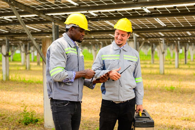 équipe d'ingénieurs de maintenance vérifiant les panneaux solaires sur une ferme à cellules solaires photo stock