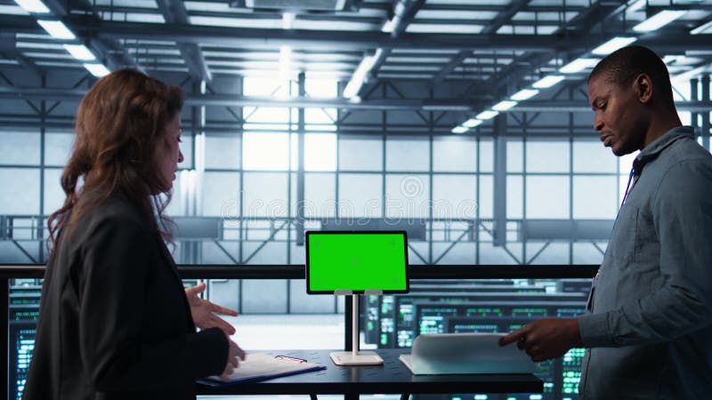 Équipe du centre de données utilisant une tablette mockage à écran vert examen de la paperasse clips vidéos