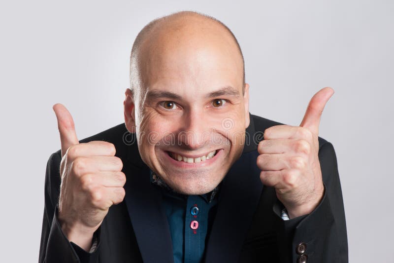 Équipez composer un visage idiot et donner le pouce photographie stock libre de droits Équipez composer un visage idiot et donner le pouce photographie stock libre de droits