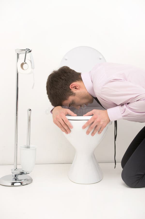Équipez l'agenouillement vers le bas dans la salle de bains, vomissant dans la toilette. Jeune type se tenant au-dessus du siège des toilettes avec le lien