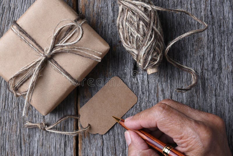 Équipez l'écriture sur une étiquette vide de cadeau de Noël photographie stock libre de droits Équipez l'écriture sur une étiquette vide de cadeau de Noël photographie stock libre de droits