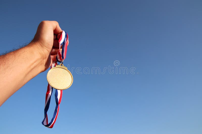 Équipez la main augmentée, en tenant la médaille d'or vide contre le ciel concept de récompense et de victoire Pour la moquerie photos libres de droits Équipez la main augmentée, en tenant la médaille d'or vide contre le ciel concept de récompense et de victoire Pour la moquerie photos libres de droits