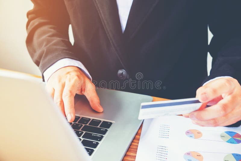 Équipez la main tenant la carte de crédit utilisant la banque en ligne d'ordinateur portable de clavier images stock Équipez la main tenant la carte de crédit utilisant la banque en ligne d'ordinateur portable de clavier images stock