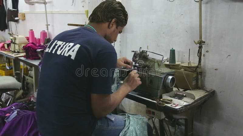 Équipez la préparation pour travailler à une machine à coudre dans l'atelier dans Mumbai, vue arrière banque de vidéos