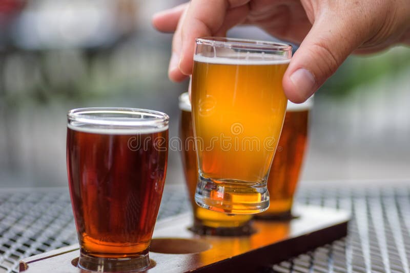 Équipez le vol de bière d'échantillonnage à un taphouse extérieur images libres de droits Équipez le vol de bière d'échantillonnage à un taphouse extérieur images libres de droits