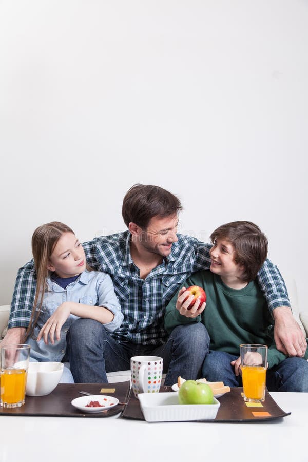Équipez prendre un petit déjeuner avec vos deux enfants photographie stock libre de droits Équipez prendre un petit déjeuner avec vos deux enfants photographie stock libre de droits