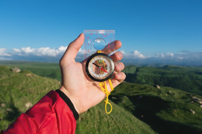 Équipez rechercher la direction avec une boussole dans sa main dans le point de vue de montagnes d'été Recherche de direction photos libres de droits Équipez rechercher la direction avec une boussole dans sa main dans le point de vue de montagnes d'été Recherche de direction photos libres de droits