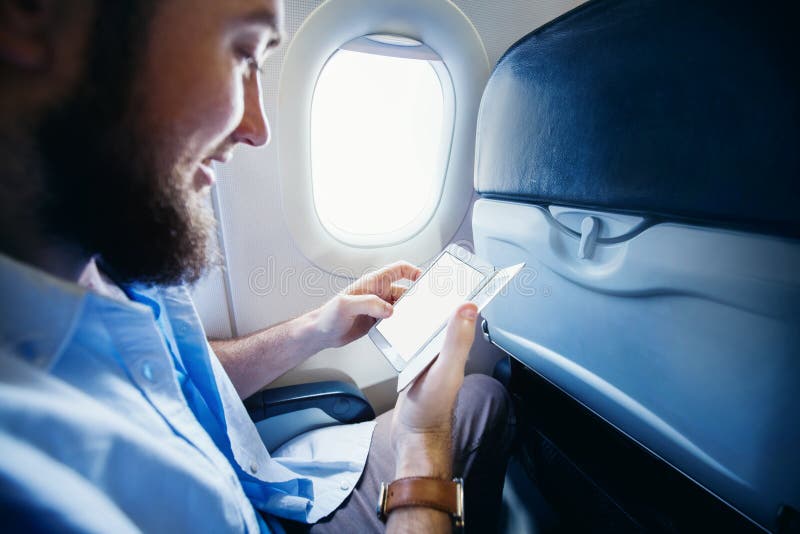Équipez tenir un téléphone intelligent avec l'écran vide dans l'avion photographie stock libre de droits Équipez tenir un téléphone intelligent avec l'écran vide dans l'avion photographie stock libre de droits