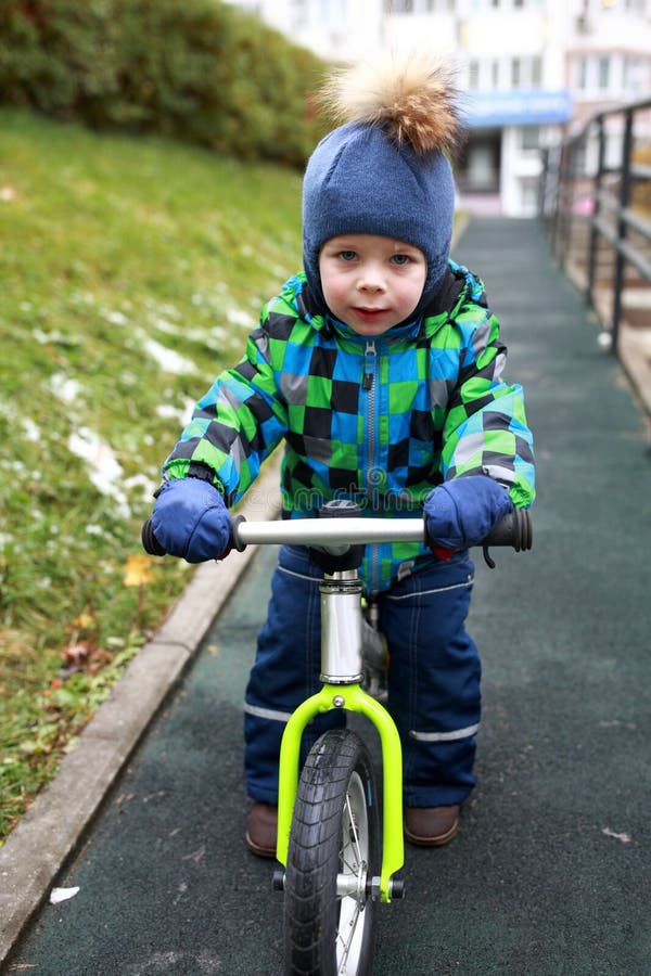 Équitation de garçon sur le vélo d'équilibre photographie stock Équitation de garçon sur le vélo d'équilibre photographie stock