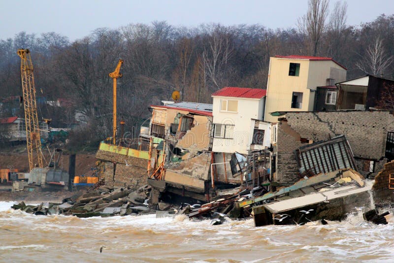 Érosion côtière - les maisons construites sur le sol d'argile faible glissent vers le bas à la mer photographie stock libre de droits Érosion côtière - les maisons construites sur le sol d'argile faible glissent vers le bas à la mer photographie stock libre de droits