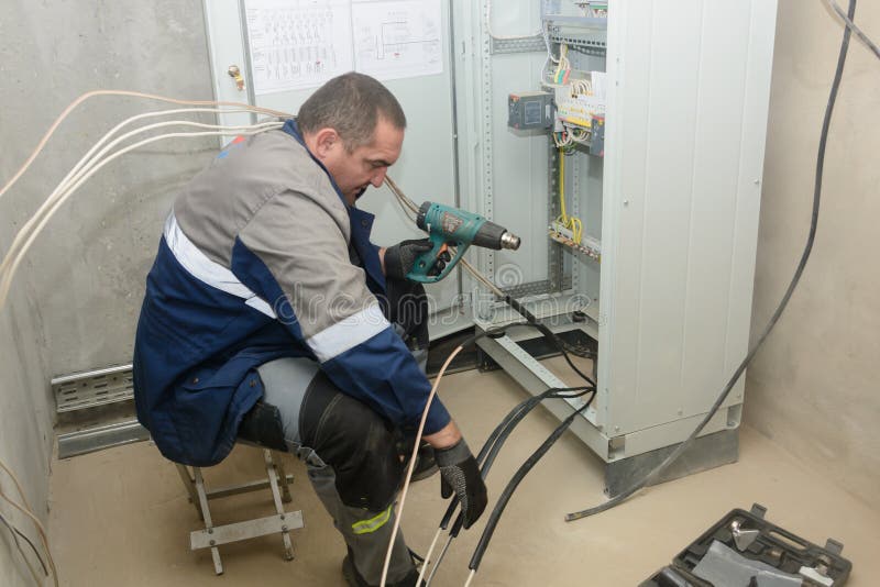 établissant la connexion de la glande de câble pour la connexion aux réseaux électriques. ingénieur électrique au travail photos libres de droits