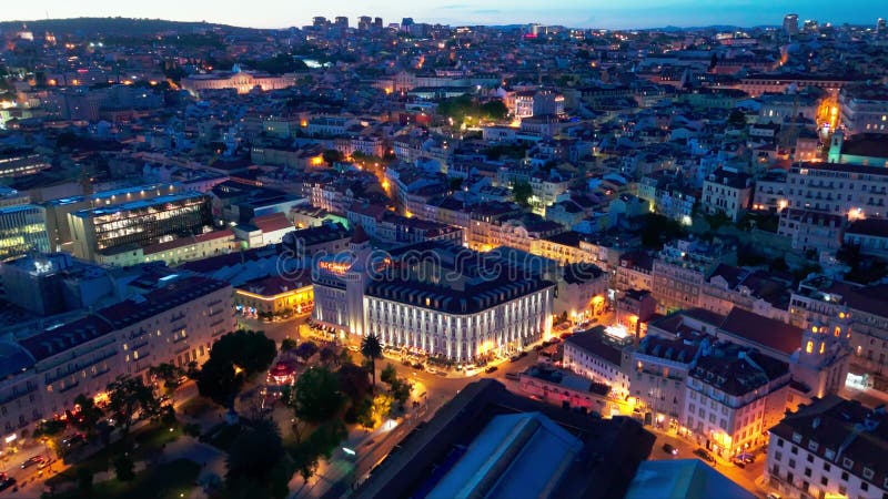 établissant une vue aérienne de la vieille ville illuminée de lisbonne et de la rivière tagus la nuit. heure bleue. portugal. dron