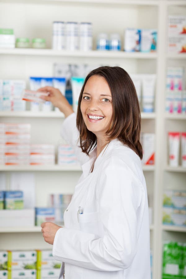 Étagères de Taking Medicine From de pharmacien à la pharmacie photo libre de droits Étagères de Taking Medicine From de pharmacien à la pharmacie photo libre de droits