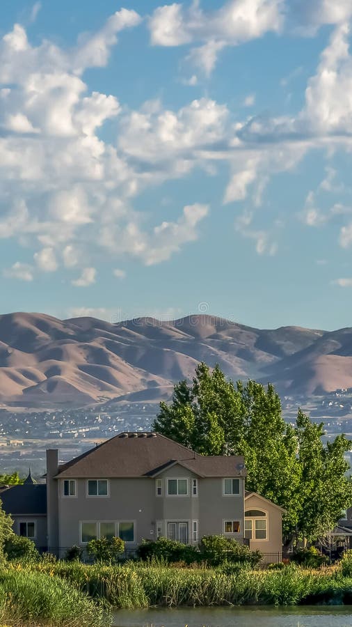 Étang vertical et terrain herbeux devant les maisons avec vue sur la vallée et la montagne photo stock