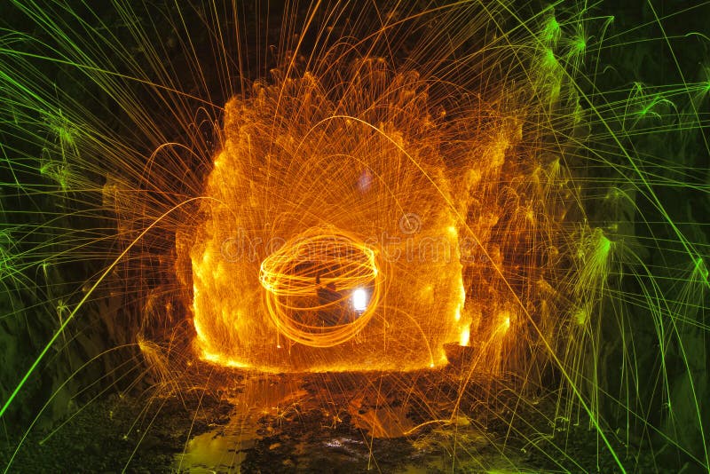 Spinning Steel Wool in old train tunnel with shower of hot sparks and rock walls. Spinning Steel Wool in old train tunnel with shower of hot sparks and rock walls.