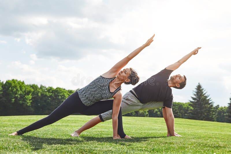 Étirage de couples Jeunes couples étirant et faisant des exercices de yoga en nature un matin ensoleillé Style de vie sain photo libre de droits Étirage de couples Jeunes couples étirant et faisant des exercices de yoga en nature un matin ensoleillé Style de vie sain photo libre de droits