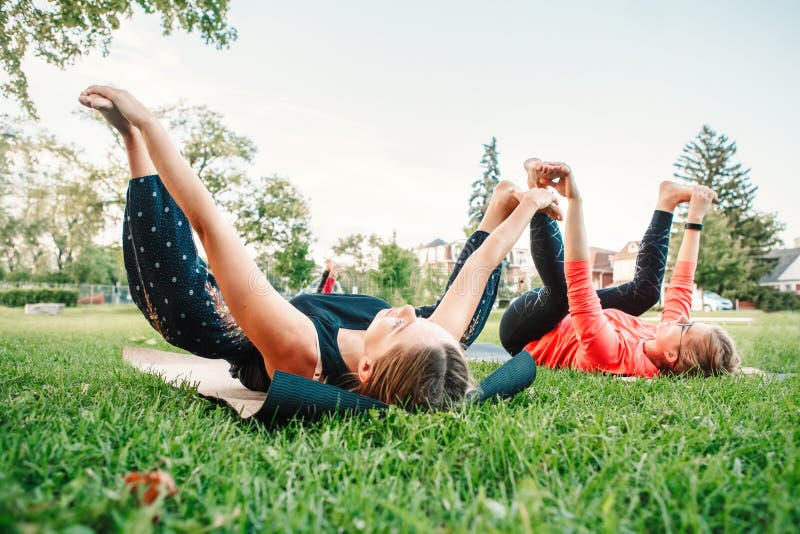 Étirage de femmes, exécutant la séance d'entraînement dehors photos stock Étirage de femmes, exécutant la séance d'entraînement dehors photos stock