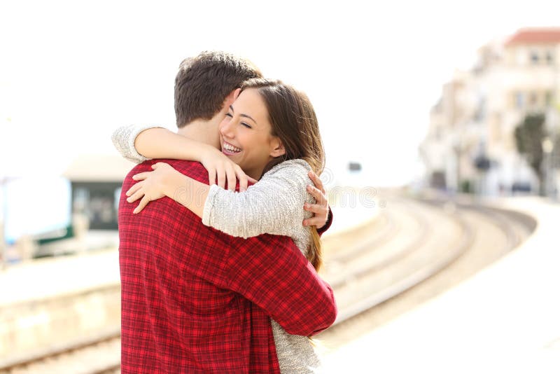 Étreindre de couples heureux dans une station de train photo libre de droits Étreindre de couples heureux dans une station de train photo libre de droits