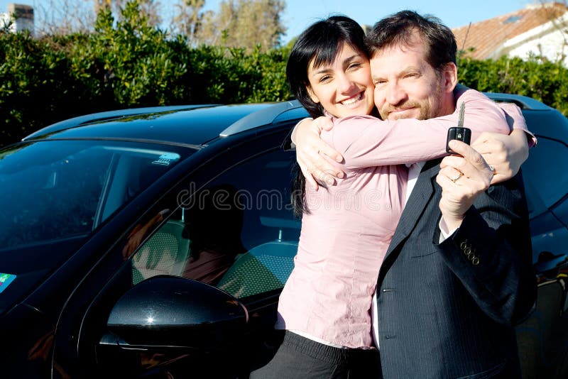 Étreindre mignon de couples heureux pour la nouvelle voiture photos libres de droits Étreindre mignon de couples heureux pour la nouvelle voiture photos libres de droits