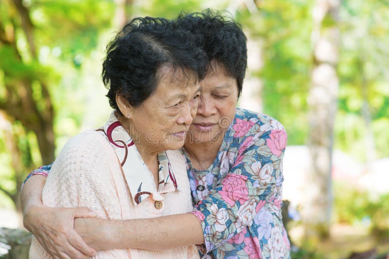 Étreintes mûres asiatiques de femme et consolation de sa vieille mère pleurante