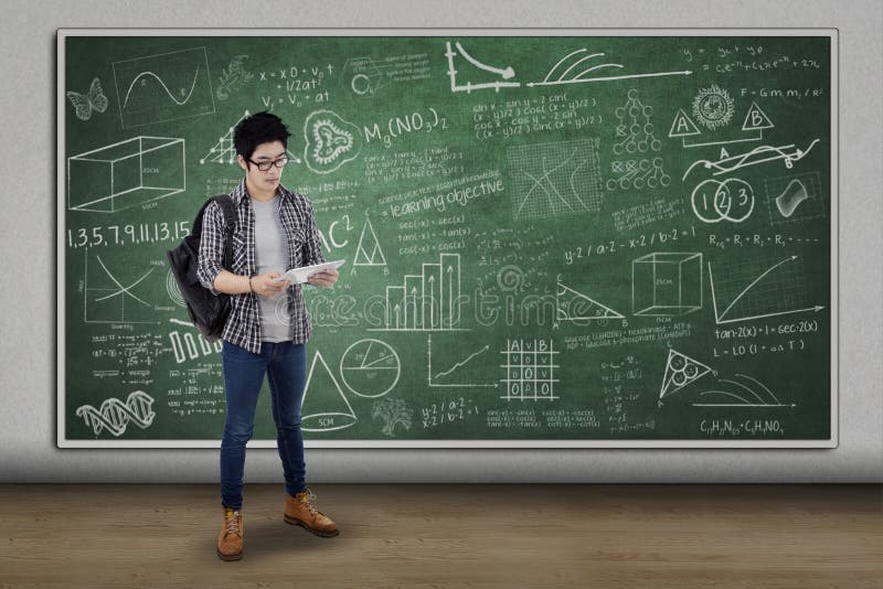 Étudiant avec le comprimé numérique se tenant dans la classe photos libres de droits Étudiant avec le comprimé numérique se tenant dans la classe photos libres de droits