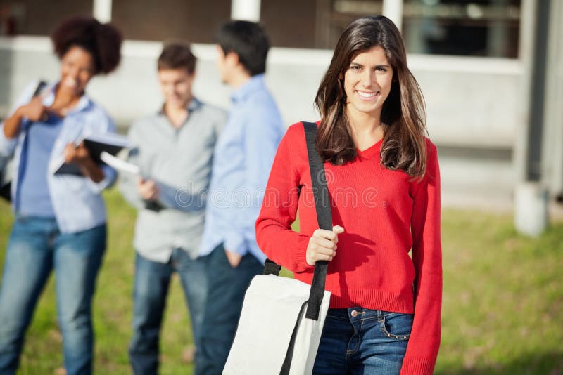 Étudiant Carrying Shoulder Bag sur le campus universitaire photographie stock libre de droits Étudiant Carrying Shoulder Bag sur le campus universitaire photographie stock libre de droits