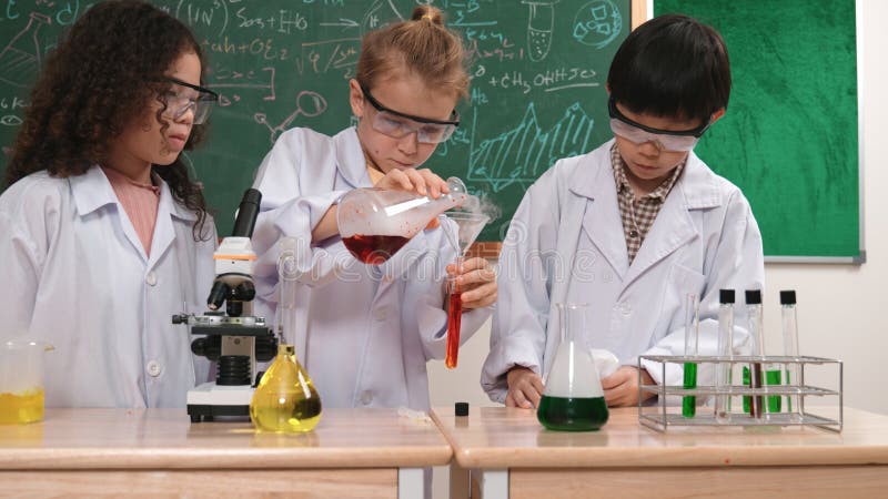 étudiant caucasien faisant l'expérience et la solution de coulée au laboratoire. pédagogie. photo libre de droits