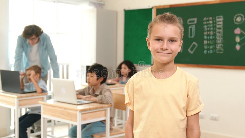 étudiant caucasien regardant la caméra tandis qu'un ami étudie le code. pédagogie. image stock
