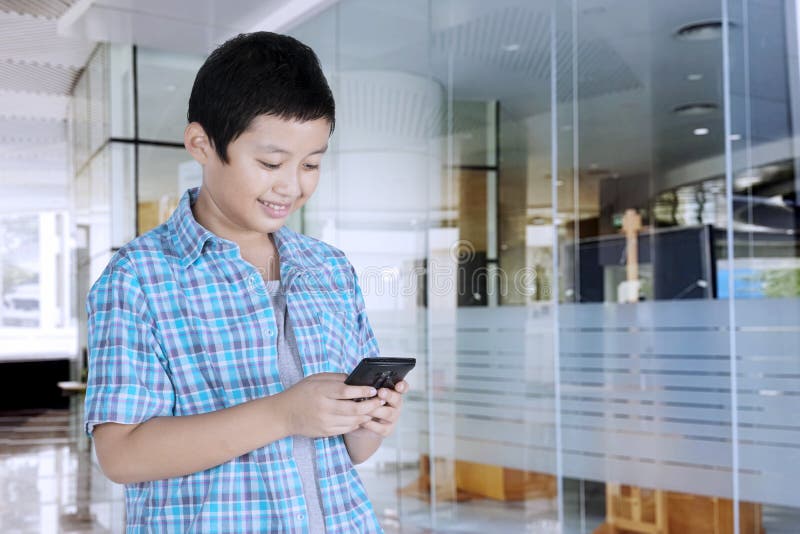 Étudiant de la préadolescence bel à l'aide d'un smartphone image libre de droits Étudiant de la préadolescence bel à l'aide d'un smartphone image libre de droits