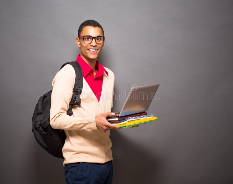 Étudiant latin bel avec l'ordinateur portable dans le studio photographie stock libre de droits Étudiant latin bel avec l'ordinateur portable dans le studio photographie stock libre de droits