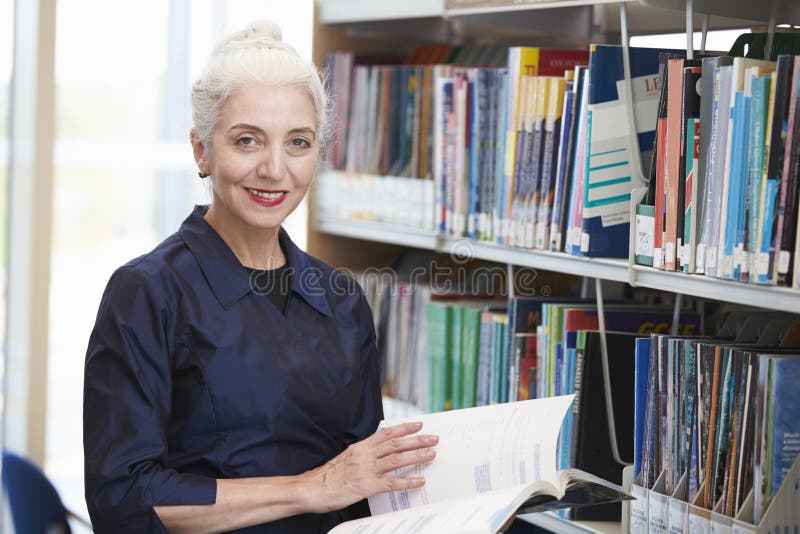 Étudiant mûr féminin Studying In Library photo libre de droits Étudiant mûr féminin Studying In Library photo libre de droits