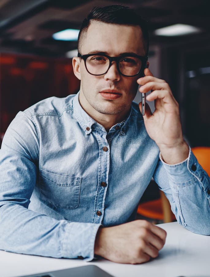 étudiant pensif hipster habillé en chemise denim parlant sur cellulaire photos stock