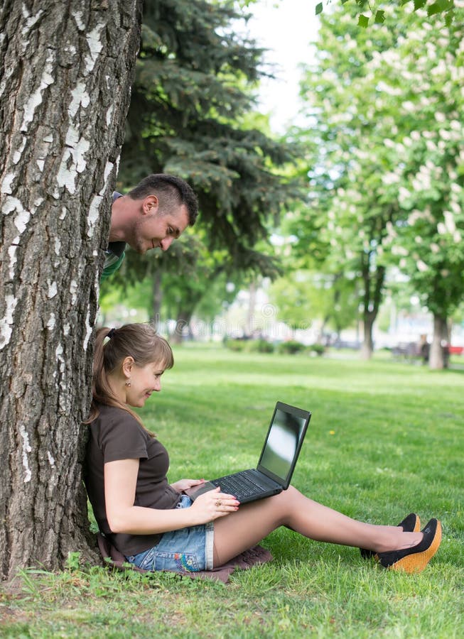 Étudiant universitaire de métis s'asseyant sur le fonctionnement d'herbe images libres de droits Étudiant universitaire de métis s'asseyant sur le fonctionnement d'herbe images libres de droits