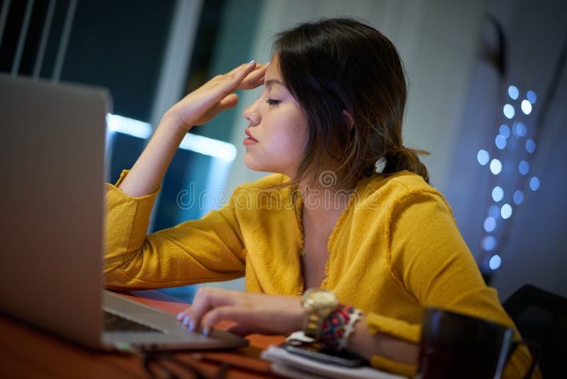 Étudiant universitaire With Headache Studying de fille la nuit photos libres de droits Étudiant universitaire With Headache Studying de fille la nuit photos libres de droits