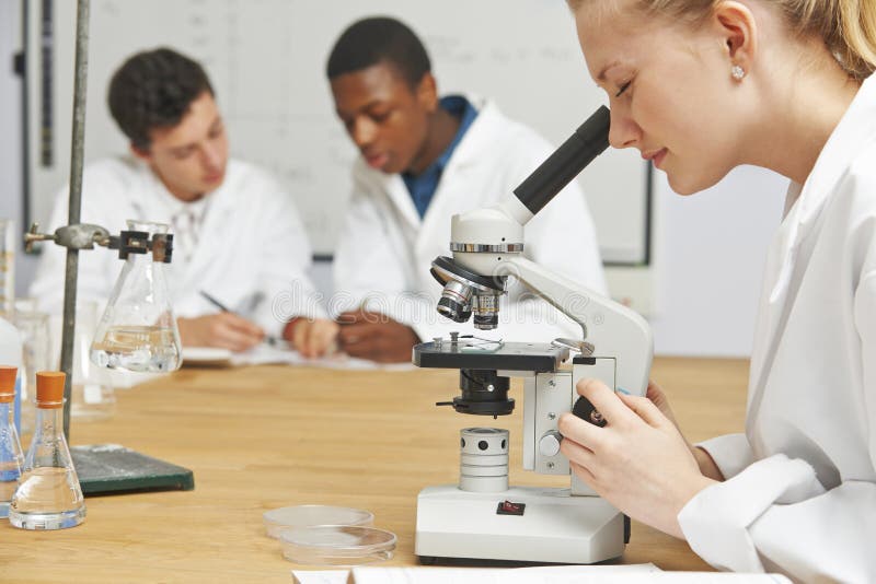 Étudiants adolescents dans la classe de la Science utilisant le microscope images stock Étudiants adolescents dans la classe de la Science utilisant le microscope images stock