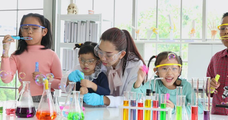 Étudiants et bulles de soufflement de professeur dans le laboratoire