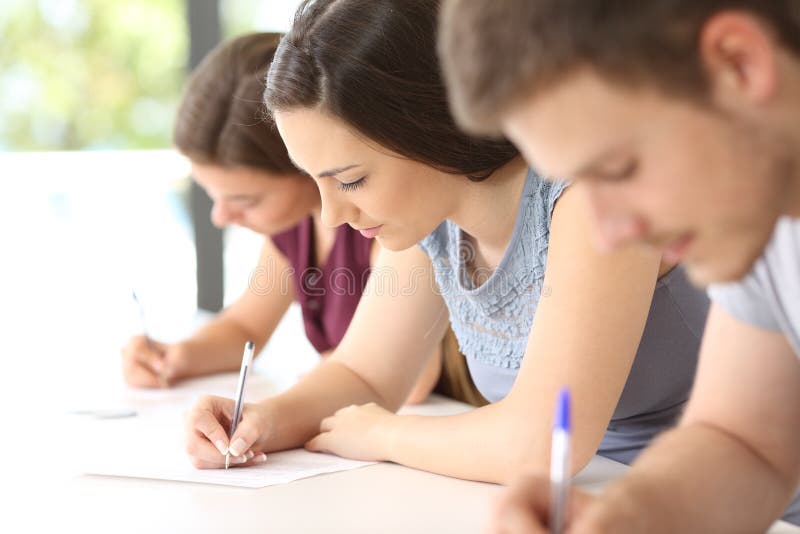 Étudiants faisant un examen dans une salle de classe photographie stock Étudiants faisant un examen dans une salle de classe photographie stock