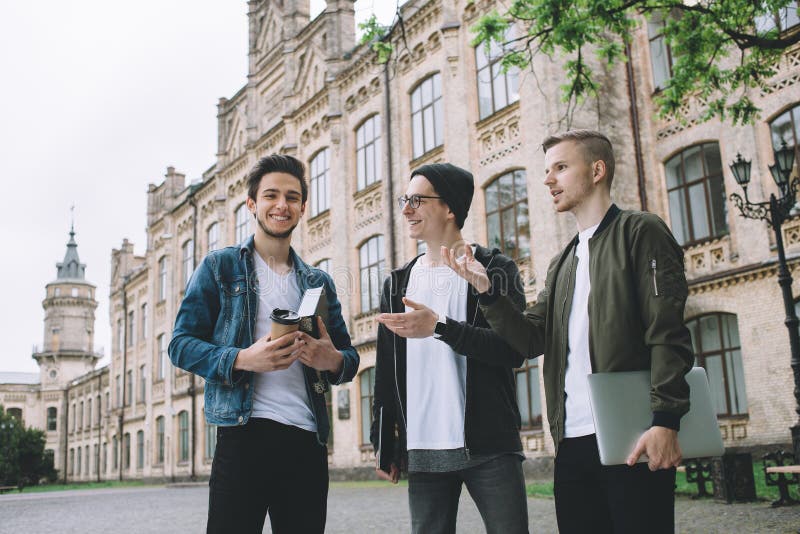 Étudiants heureux réussis tenant le campus ou l'université proche dehors photos stock Étudiants heureux réussis tenant le campus ou l'université proche dehors photos stock