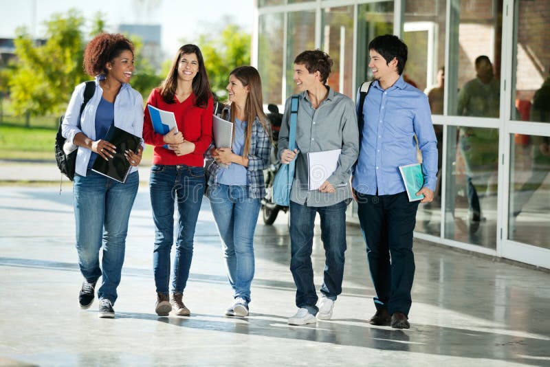 Full length of happy multiethnic students walking together on college campus. Full length of happy multiethnic students walking together on college campus